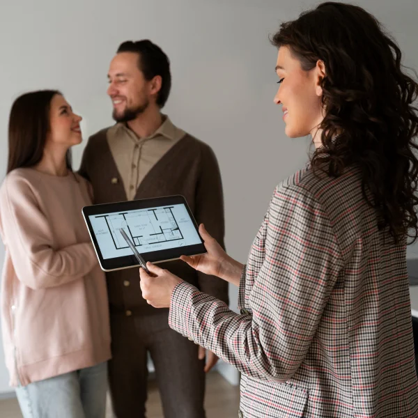 Un homme et une femme se tiennent devant une tablette, discutant d'estimations.